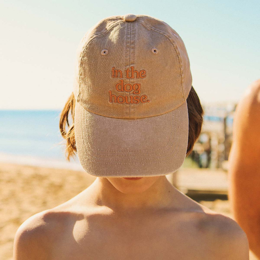 Close up of the in the dog house embroidery on the brown kids cotton cap