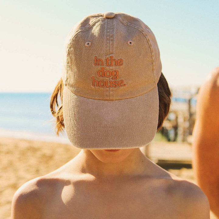 Close up of the in the dog house embroidery on the brown kids cotton cap