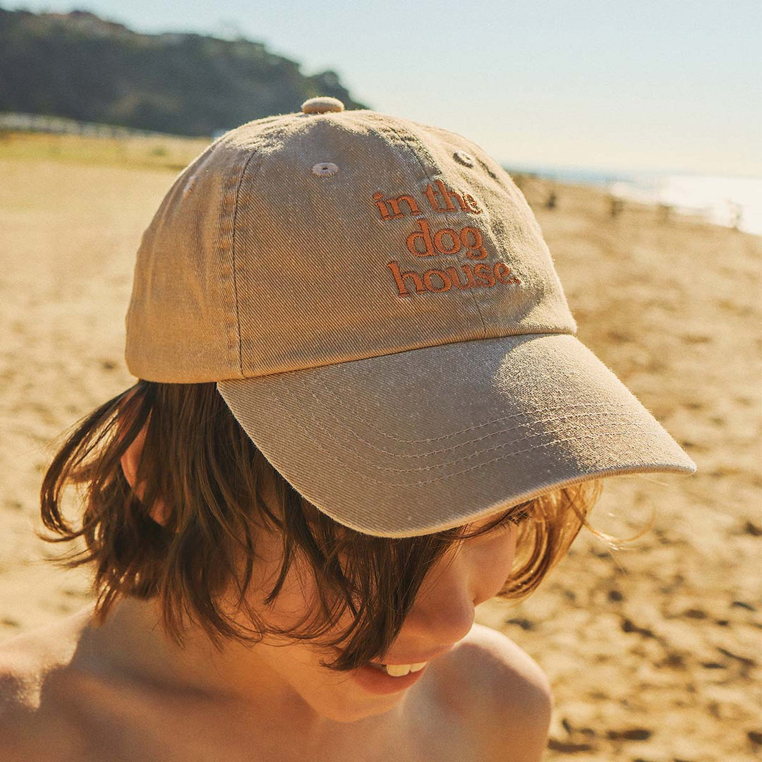Kid on the beach in the Dog House kids cotton cap in brown