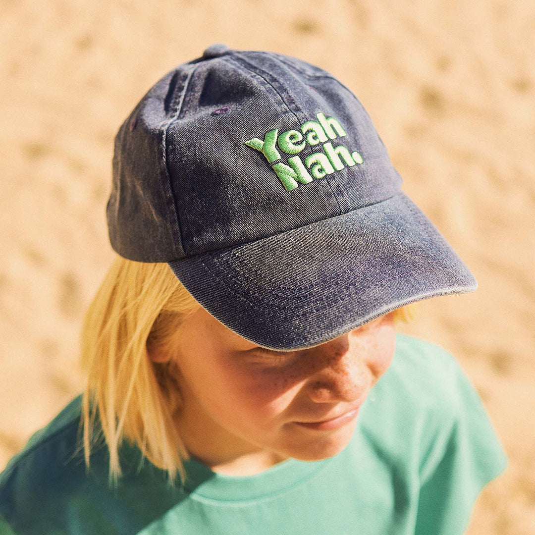 Kid looking down in the Yeah Nah kids cotton cap in navy