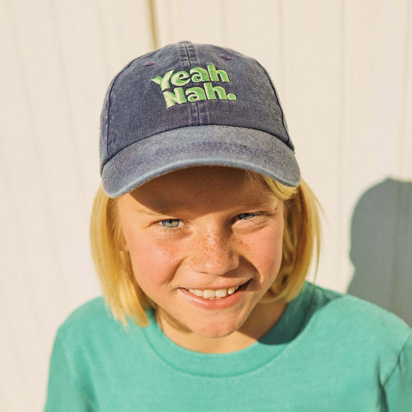 Boy wearing the Yeah Nah kids cotton cap in navy denim