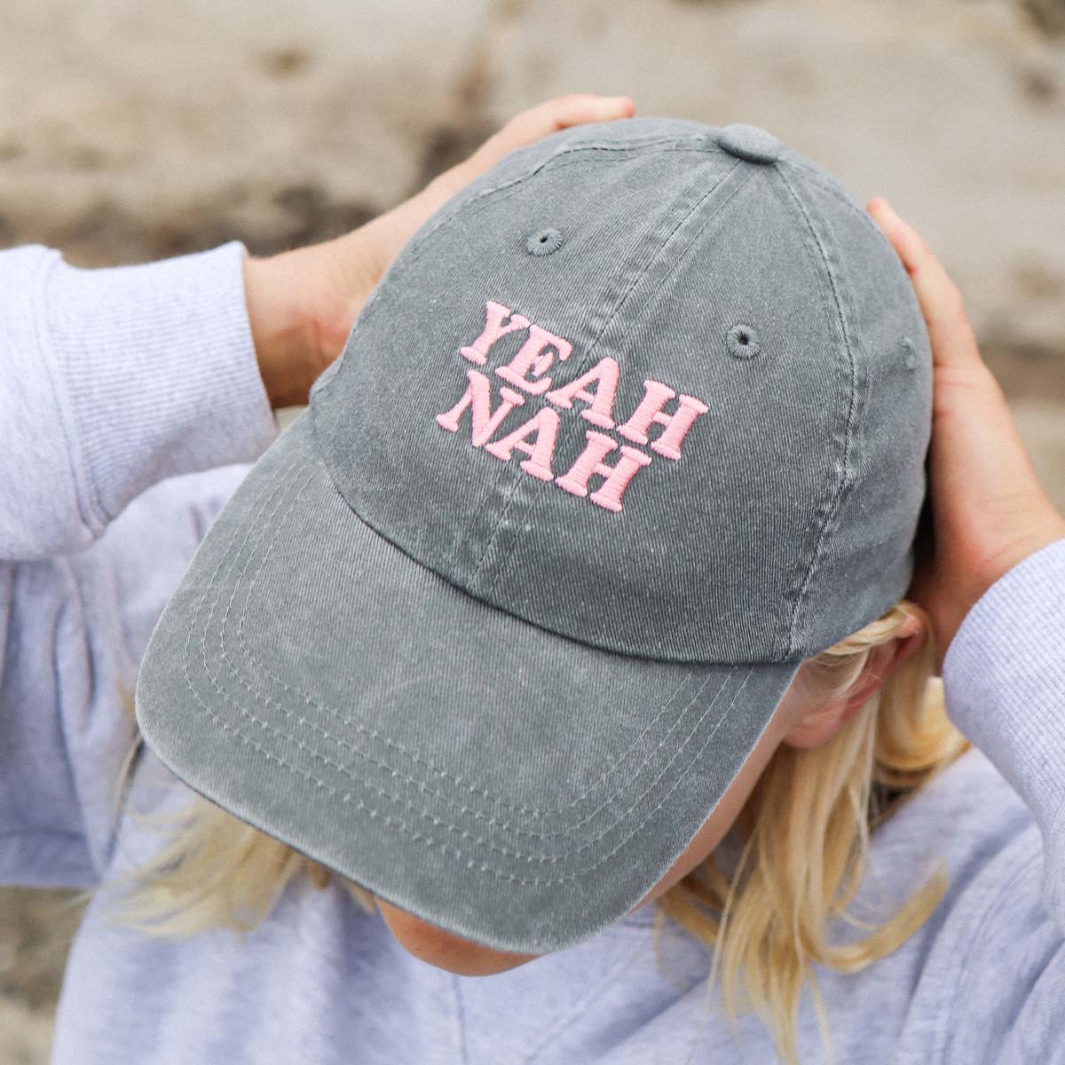 Kid adjusting the charcoal Yeah Nah kids cotton cap