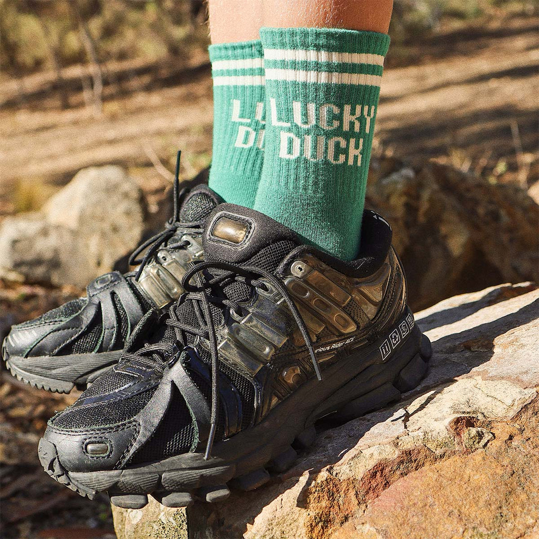 Kids Lucky Duck socks in green worn with hiking boots