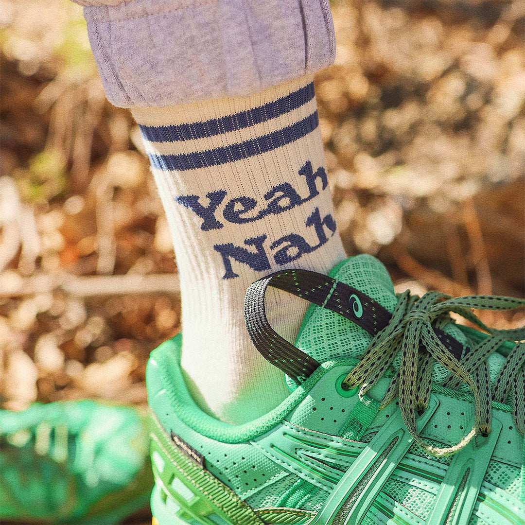 White Yeah Nah kids crew socks worn outdoors