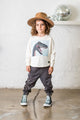 A little girl wearing a hat and a Rock your Baby Online SMILE DINO T-SHIRT.
