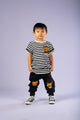 A young boy wearing a Rock your Baby Online Strikey Tiger t-shirt and joggers.