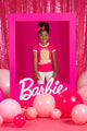 A young girl is standing in front of pink balloons and a Rock your Baby Online Barbie Girl T-shirt.