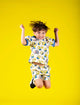A young boy jumping in the air while wearing Rock your Baby Online's Minions Mayhem Shorts.