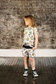A little girl wearing a Summer Daze T-Shirt and shorts from Rock your Baby Online.